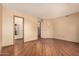 Well-lit bedroom with wood-look floors and access to bathroom at 10161 W Pineaire Dr, Sun City, AZ 85351