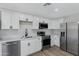 Modern kitchen with white cabinets, stainless steel appliances, and quartz countertops at 1104 N Oak Ct, Gilbert, AZ 85233