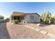 Backyard view of manufactured home with covered patio and stone path at 1126 S 97Th Way, Mesa, AZ 85208