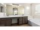 Bathroom with double vanity, large mirror, and soaking tub at 11670 W Pine Mountain Ct, Surprise, AZ 85378