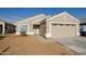 Beige house with a two-car garage and landscaped yard at 12750 W Dreyfus Dr, El Mirage, AZ 85335