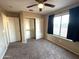 Bright bedroom featuring a large window, ceiling fan, and spacious closet at 13943 S Amado Blvd, Arizona City, AZ 85123