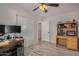 Bedroom with wood-look floors, ceiling fan, and built-in desk at 1510 E Ironwood Dr, Buckeye, AZ 85326