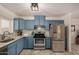 Modern kitchen with blue cabinets, stainless steel appliances, and granite countertops at 1510 E Ironwood Dr, Buckeye, AZ 85326