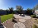 Beautiful backyard featuring a stone patio, artificial grass, gravel landscaping, and a modern fire pit at 17066 W Seldon Ln, Waddell, AZ 85355