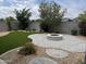 Professionally landscaped backyard with artificial turf, stone patio with fire pit, and mature trees at 17066 W Seldon Ln, Waddell, AZ 85355
