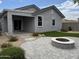 Relaxing backyard retreat with a covered patio, artificial grass, stone fire pit, and manicured landscaping at 17066 W Seldon Ln, Waddell, AZ 85355