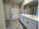 Bathroom with double sinks, white cabinets, and a shower-tub combo at 17066 W Seldon Ln, Waddell, AZ 85355