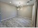 Dining room with modern light fixture, wood-look flooring, and neutral walls at 17066 W Seldon Ln, Waddell, AZ 85355