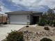Charming single-story home featuring a two-car garage and desert landscaping with a stone facade and covered entrance at 17066 W Seldon Ln, Waddell, AZ 85355