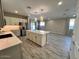 Open-concept kitchen with quartz island flows into the dining and living areas at 17066 W Seldon Ln, Waddell, AZ 85355
