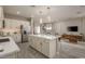 Modern kitchen with white cabinets, a large island, and stainless steel appliances at 17066 W Seldon Ln, Waddell, AZ 85355