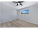 Bright bedroom with ceiling fan, large window, and light wood flooring at 2046 E Alder Cir, Mesa, AZ 85204