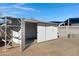 White metal storage shed with shelving and double doors at 2046 E Alder Cir, Mesa, AZ 85204