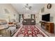 Living area with a brown sofa, area rug, and a ceiling fan at 2135 N St Pedro Ave, Casa Grande, AZ 85122