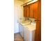 Laundry room with washer, dryer, and wood cabinets at 2300 W Temple St, Chandler, AZ 85224