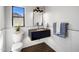 Modern bathroom with a sleek floating vanity, black countertop, and views of the mountains at 25838 N 104Th Pl, Scottsdale, AZ 85255