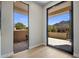 Hallway with large glass doors showcasing views of the outdoor patio and desert landscape at 25838 N 104Th Pl, Scottsdale, AZ 85255