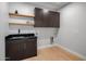 Laundry room with dark cabinetry and floating shelves at 25838 N 104Th Pl, Scottsdale, AZ 85255