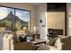 Sunlit living room featuring a cozy fireplace and stunning mountain views at 25838 N 104Th Pl, Scottsdale, AZ 85255