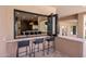 Outdoor bar area with seating, a sink, and a pass-through window to the kitchen with nice finishes and appliances at 25838 N 104Th Pl, Scottsdale, AZ 85255