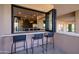 Outdoor bar with seating, providing a view into the kitchen at 25838 N 104Th Pl, Scottsdale, AZ 85255