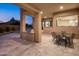 Covered patio with outdoor kitchen, grill, dining table, and picturesque mountain views at dusk at 25838 N 104Th Pl, Scottsdale, AZ 85255