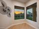 Bright sitting area with floor-to-ceiling windows offering backyard views and wood floors at sunset at 25838 N 104Th Pl, Scottsdale, AZ 85255