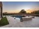 Backyard with a uniquely-shaped swimming pool, stone accents, and views of the sunset over the desert landscape at 25838 N 104Th Pl, Scottsdale, AZ 85255