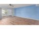 Light blue bedroom with wood-look floors and sliding glass doors at 26430 S Pinewood Dr, Sun Lakes, AZ 85248