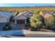 Single story home with a two-car garage and desert landscaping at 27648 N 102Nd Ln, Peoria, AZ 85383