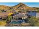 Aerial view of house with solar panels, pool, and mountain backdrop at 27648 N 102Nd Ln, Peoria, AZ 85383