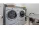 Laundry room with washer, dryer, and folding table at 27648 N 102Nd Ln, Peoria, AZ 85383