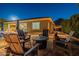 Relaxing patio area with seating and fire pit, nestled in a beautifully lit yard at 27648 N 102Nd Ln, Peoria, AZ 85383