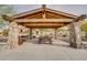 Stone picnic area with a wooden pergola and benches at 27648 N 102Nd Ln, Peoria, AZ 85383