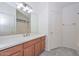 Bathroom with wood cabinets, quartz countertop, and shower at 28025 N 23Rd Dr, Phoenix, AZ 85085