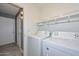 Bright laundry room includes washer, dryer, and storage shelves at 28025 N 23Rd Dr, Phoenix, AZ 85085