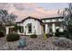 Beautiful single-story home featuring desert landscaping, warm lighting, and a tile roof against a colorful sky at 29615 N 55Th Pl, Cave Creek, AZ 85331