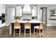 Stylish kitchen island with bar stool seating, modern lighting, and white cabinetry with lots of storage at 29615 N 55Th Pl, Cave Creek, AZ 85331