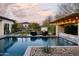 Resort-style backyard featuring a sparkling pool, fire pit, a covered outdoor kitchen and mature landscaping at 29615 N 55Th Pl, Cave Creek, AZ 85331