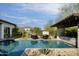 Inviting pool with waterfall feature, desert landscaping, and cozy outdoor seating under a pergola at 29615 N 55Th Pl, Cave Creek, AZ 85331
