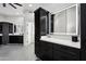 Modern bathroom with dark cabinetry, quartz countertops, and a large mirror at 3611 E Kachina Dr, Phoenix, AZ 85044