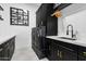 Laundry room with black cabinets, quartz countertops, and modern sink at 3611 E Kachina Dr, Phoenix, AZ 85044