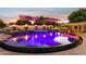 Large luxury pool with a spa and fire features at twilight at 3611 E Kachina Dr, Phoenix, AZ 85044