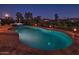 Inviting kidney-shaped pool with surrounding patio at night at 3649 N Hudson Dr, Florence, AZ 85132