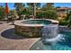 Stone spa with waterfall feature flowing into pool at 3649 N Hudson Dr, Florence, AZ 85132