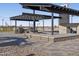 Outdoor kitchen with grills and seating under a shaded pergola at 37053 W La Paz St, Maricopa, AZ 85138