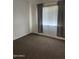 Neutral bedroom featuring neutral carpet, bright natural light, and gray draperies at 4714 E Broadway Rd, Phoenix, AZ 85040