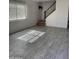 Spacious living room highlighting gray tile floors, natural light and staircase with black rails at 4714 E Broadway Rd, Phoenix, AZ 85040