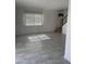 Bright living room featuring gray tile floors, a staircase with black rails, and a window at 4714 E Broadway Rd, Phoenix, AZ 85040